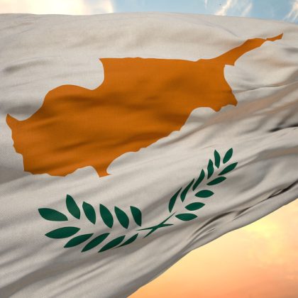 A closeup view of the flag of the Cyprus on a background of sunset