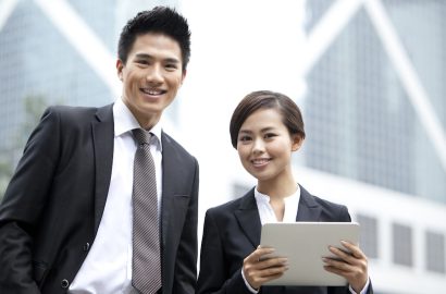 Happy Chinese business partners with digital tablet, Hong Kong